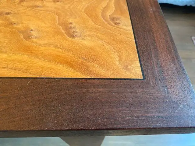 Close-up of figured elm tabletop framed by a dark English walnut border